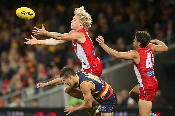 ADELAIDE, AUSTRALIA - APRIL 16: Isaac Heeney of the Swans flies over Luke Brown of the Crows during the 2016 AFL Round 04 match between the Adelaide Crows and the Sydney Swans at the Adelaide Oval on April 16, 2016 in Adelaide, Australia. (Photo by James Elsby/AFL Media/Getty Images)
