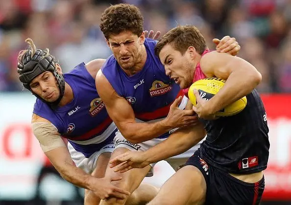 MELBOURNE, AUSTRALIA - MAY 15: Jack Viney of the Demons fends off Caleb Daniel (left) and Tom Liberatore of the Bulldogs during the 2016 AFL Round 08 match between the Melbourne Demons and the Western Bulldogs at the Melbourne Cricket Ground, Melbourne on May 15, 2016. (Photo by Michael Willson/AFL Media/Getty Images)
