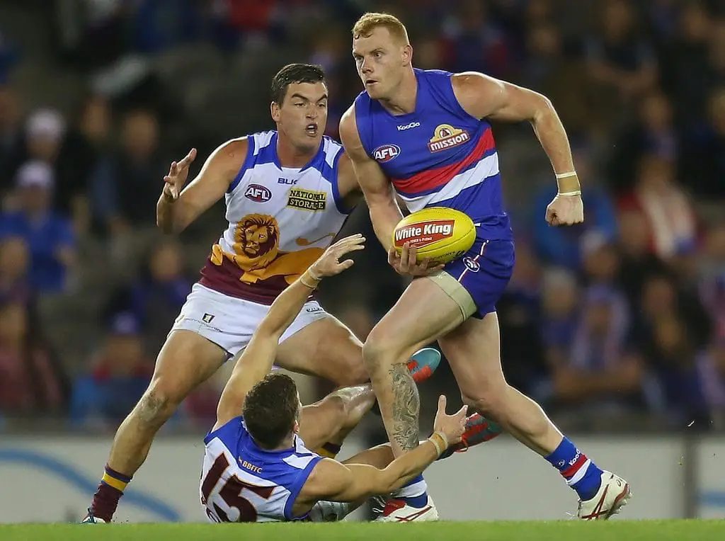 MELBOURNE, AUSTRALIA - JUNE 07: Adam Cooney of the Bulldogs is tackled during the round 12 AFL match between the Western Bulldogs and the Brisbane Lions at Etihad Stadium on June 7, 2014 in Melbourne, Australia. (Photo by Scott Barbour/Getty Images)