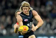 MELBOURNE, AUSTRALIA - MAY 25: Tom De Koning of the Blues handballs whilst being tackled by Noah Anderson of the Suns during the round 11 AFL match between Carlton Blues and Gold Coast Suns at Marvel Stadium, on May 25, 2024, in Melbourne, Australia. (Photo by Josh Chadwick/AFL Photos/via Getty Images)