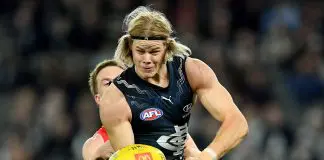 MELBOURNE, AUSTRALIA - MAY 25: Tom De Koning of the Blues handballs whilst being tackled by Noah Anderson of the Suns during the round 11 AFL match between Carlton Blues and Gold Coast Suns at Marvel Stadium, on May 25, 2024, in Melbourne, Australia. (Photo by Josh Chadwick/AFL Photos/via Getty Images)