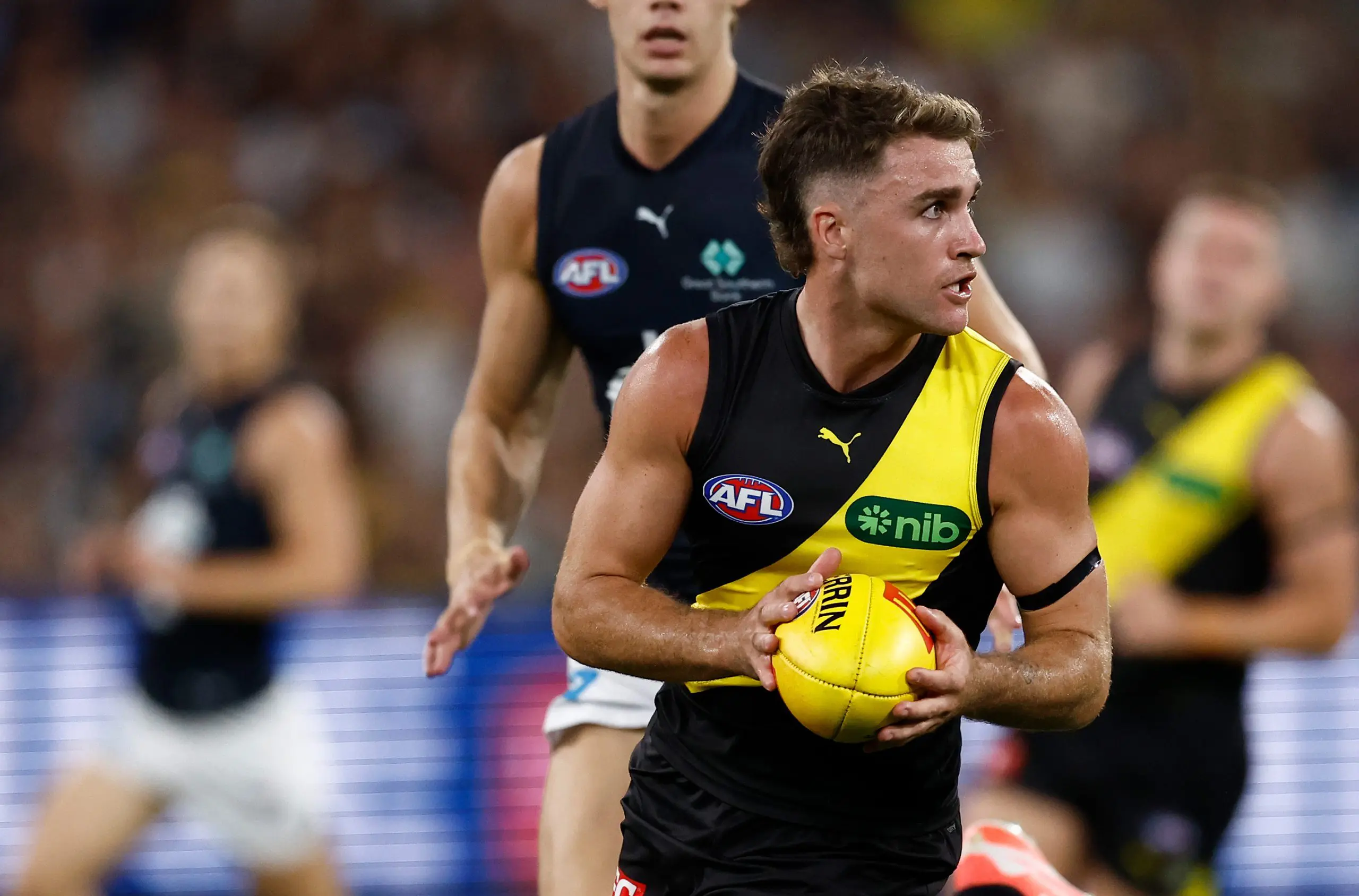 MELBOURNE, AUSTRALIA - MARCH 13: Jack Ross of the Tigers is tackled by Tom De Koning of the Blues during the 2025 AFL Round 01 match between the Richmond Tigers and the Carlton Blues at the Melbourne Cricket Ground on March 13, 2025 in Melbourne, Australia. (Photo by Michael Willson/AFL Photos via Getty Images)