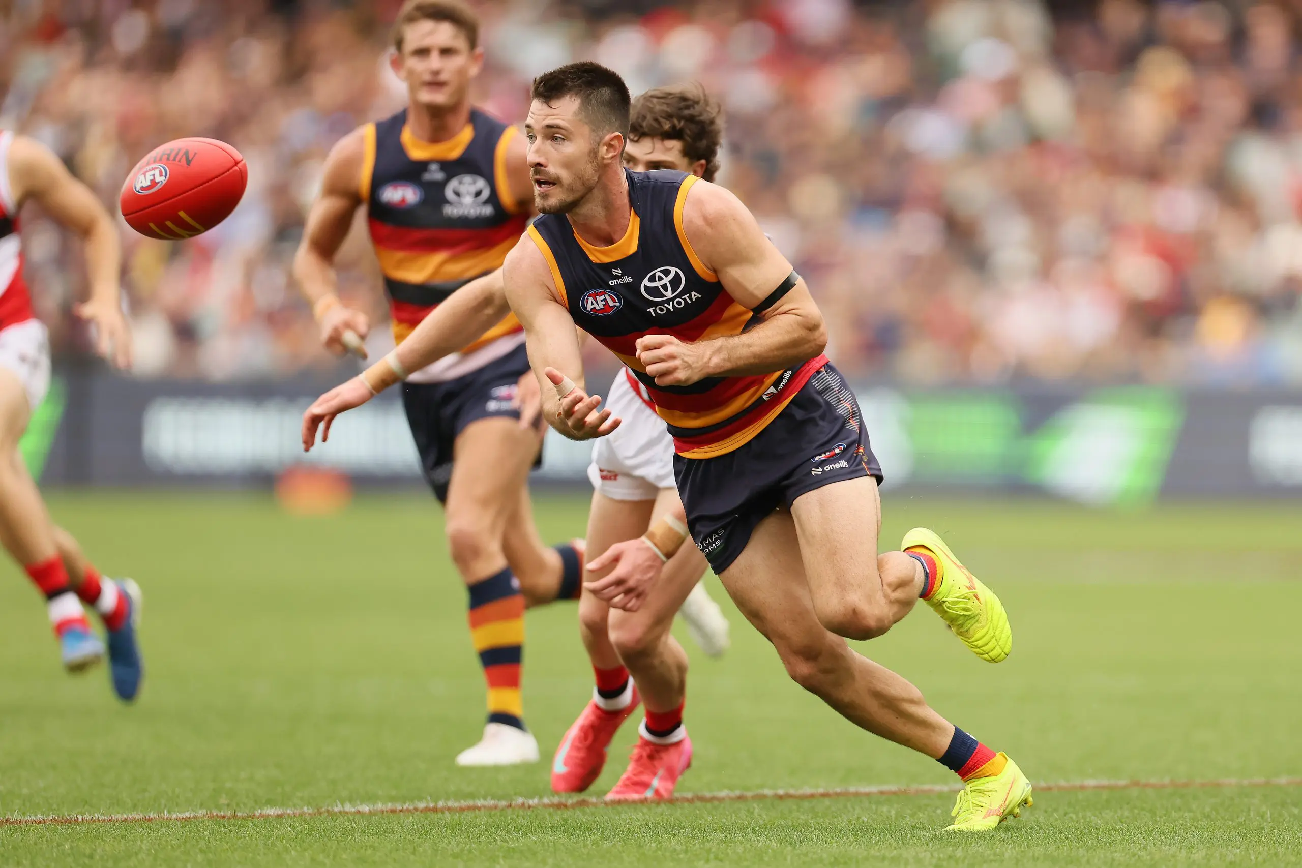 ADELAIDE, AUSTRALIA - MARCH 16: Alex Neal-Bullen of the Crows handpasses the ball during the 2025 AFL Round 01 match between the Adelaide Crows and the St Kilda Saints at Adelaide Oval on March 16, 2025 in Adelaide, Australia. (Photo by James Elsby/AFL Photos via Getty Images)