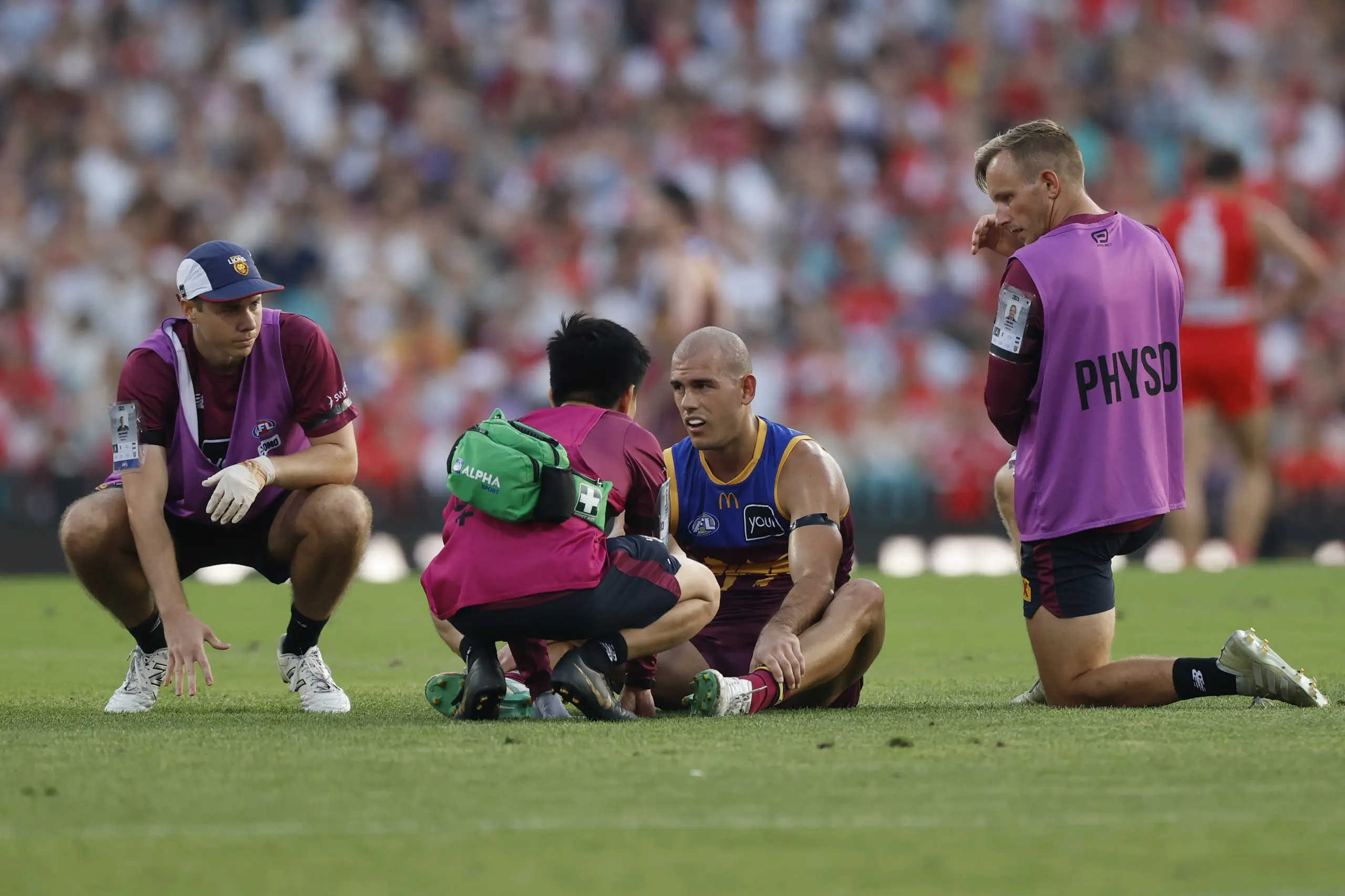 SYDNEY, AUSTRALIA - MARCH 15: Brandon Starcevich of the Lions is helped by medical staff during the round one AFL match between Sydney Swans and Brisbane Lions at Sydney Cricket Ground, on March 15, 2025, in Sydney, Australia. (Photo by Darrian Traynor/AFL Photos/via Getty Images)
