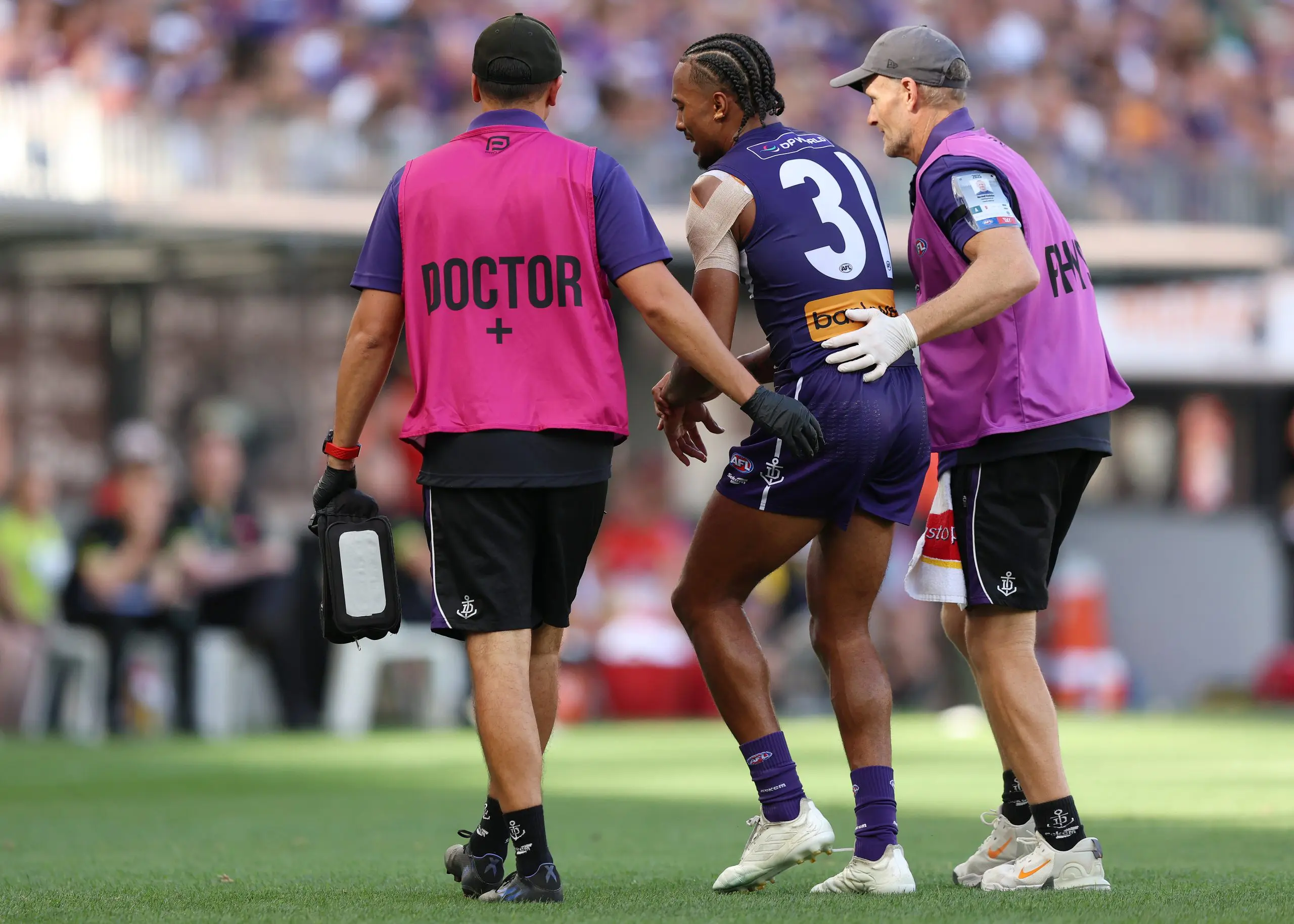 PERTH, AUSTRALIA - MARCH 23: Brandon Walker of the Dockers leaves the field injured during the 2025 AFL Round 02 match between the Fremantle Dockers and the Sydney Swans at Optus Stadium on March 23, 2025 in Perth, Australia. (Photo by Janelle St Pierre/AFL Photos via Getty Images)
