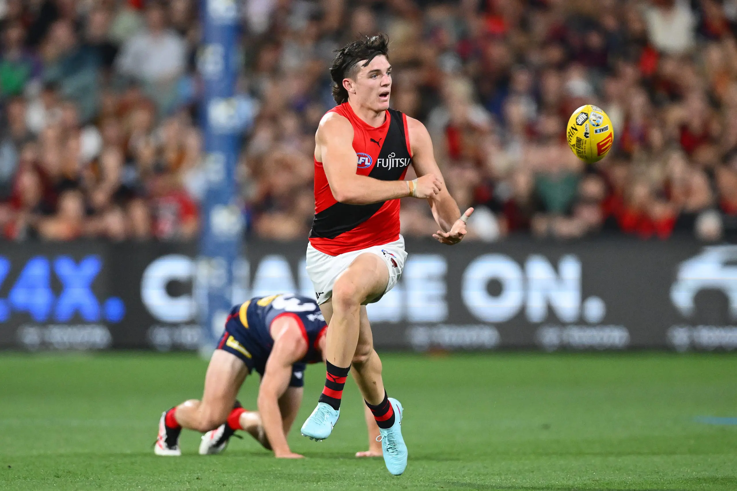 ADELAIDE, AUSTRALIA - APRIL 12: Archie Roberts of the Bombers handballs during the round five AFL match between Melbourne Demons and Essendon Bombers at Adelaide Oval, on April 12, 2025, in Adelaide, Australia. (Photo by Quinn Rooney/Getty Images via AFL Photos)