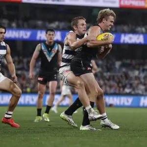 GEELONG, AUSTRALIA - MAY 10: Tom Atkins of the Cats tackles Jason Horne-Francis of the Power during the round nine AFL match between Geelong Cats and Port Adelaide Power at GMHBA Stadium, on May 10, 2024, in Geelong, Australia. (Photo by Darrian Traynor/Getty Images)