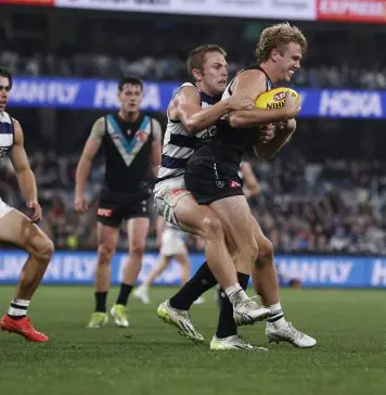 GEELONG, AUSTRALIA - MAY 10: Tom Atkins of the Cats tackles Jason Horne-Francis of the Power during the round nine AFL match between Geelong Cats and Port Adelaide Power at GMHBA Stadium, on May 10, 2024, in Geelong, Australia. (Photo by Darrian Traynor/Getty Images)