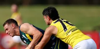 MELBOURNE, AUSTRALIA - APRIL 13: Thomas Burton of the AFL National Academy is tackled during the Marsh AFL National Academy Boys match between Australia U18 and Richmond VFL at RSEA Park on April 13, 2025 in Melbourne, Australia. (Photo by Josh Chadwick/AFL Photos/via Getty Images)