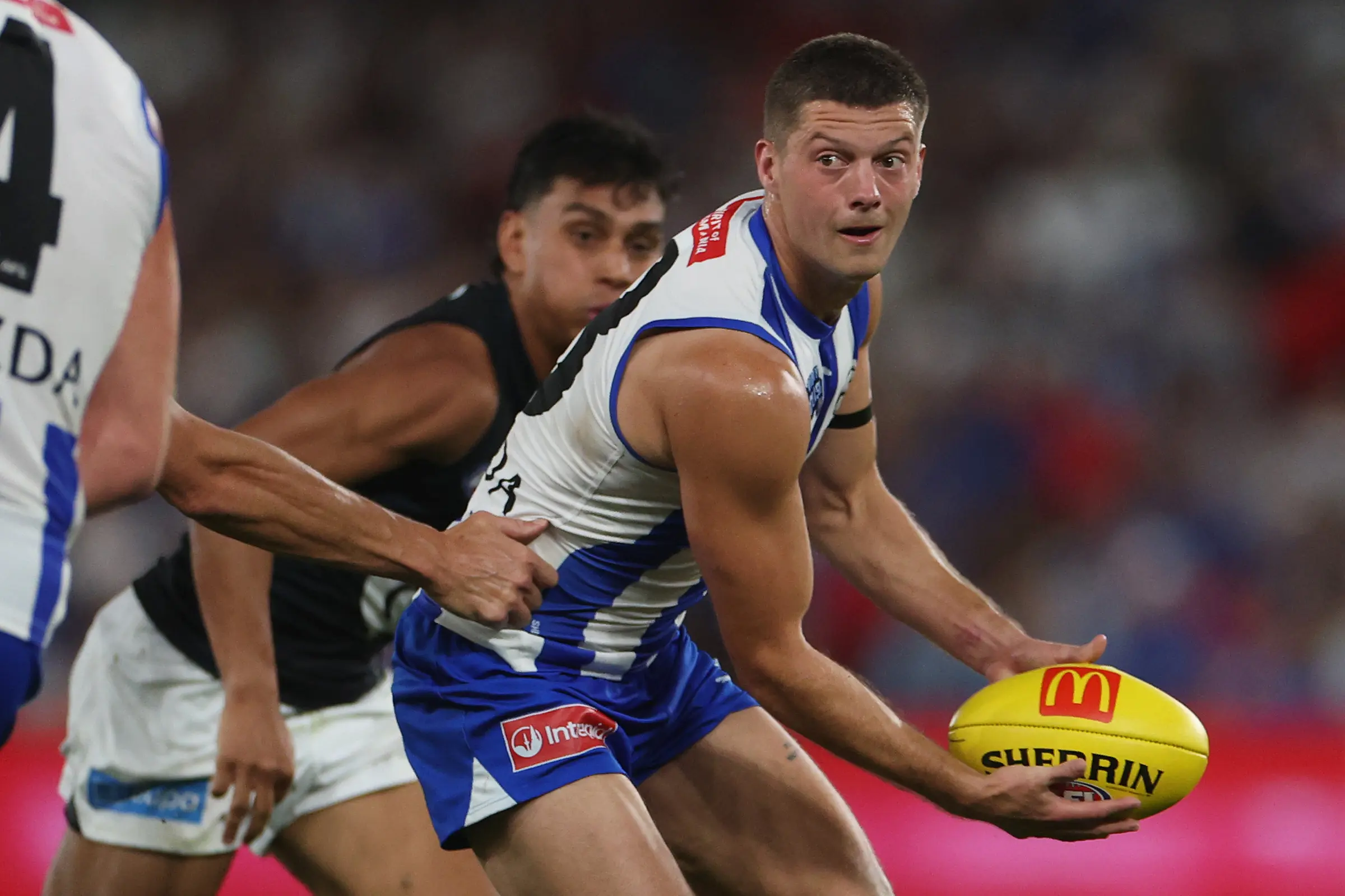 MELBOURNE, AUSTRALIA - APRIL 18: Darcy Tucker of the Kangaroos handballs under pressure during the round six AFL match between North Melbourne Kangaroos and Carlton Blues at Marvel Stadium, on April 18, 2025, in Melbourne, Australia. (Photo by Daniel Pockett/Getty Images)