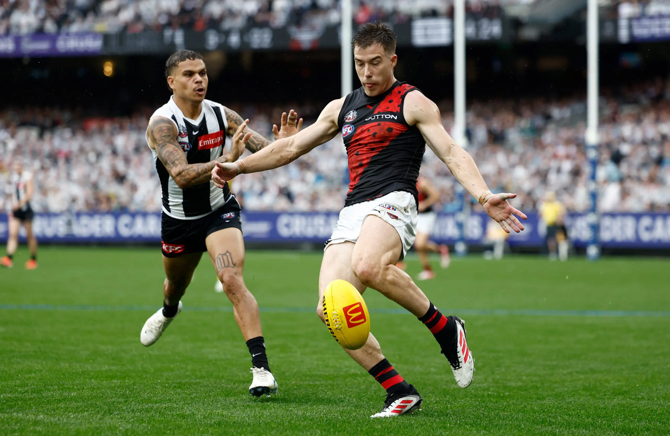 MELBOURNE, AUSTRALIA - APRIL 25: Zach Merrett of the Bombers is chased by Bobby Hill of the Magpies during the 2025 AFL Round 07 match between the Collingwood Magpies and the Essendon Bombers at the Melbourne Cricket Ground on April 25, 2025 in Melbourne, Australia. (Photo by Michael Willson/AFL Photos via Getty Images)
