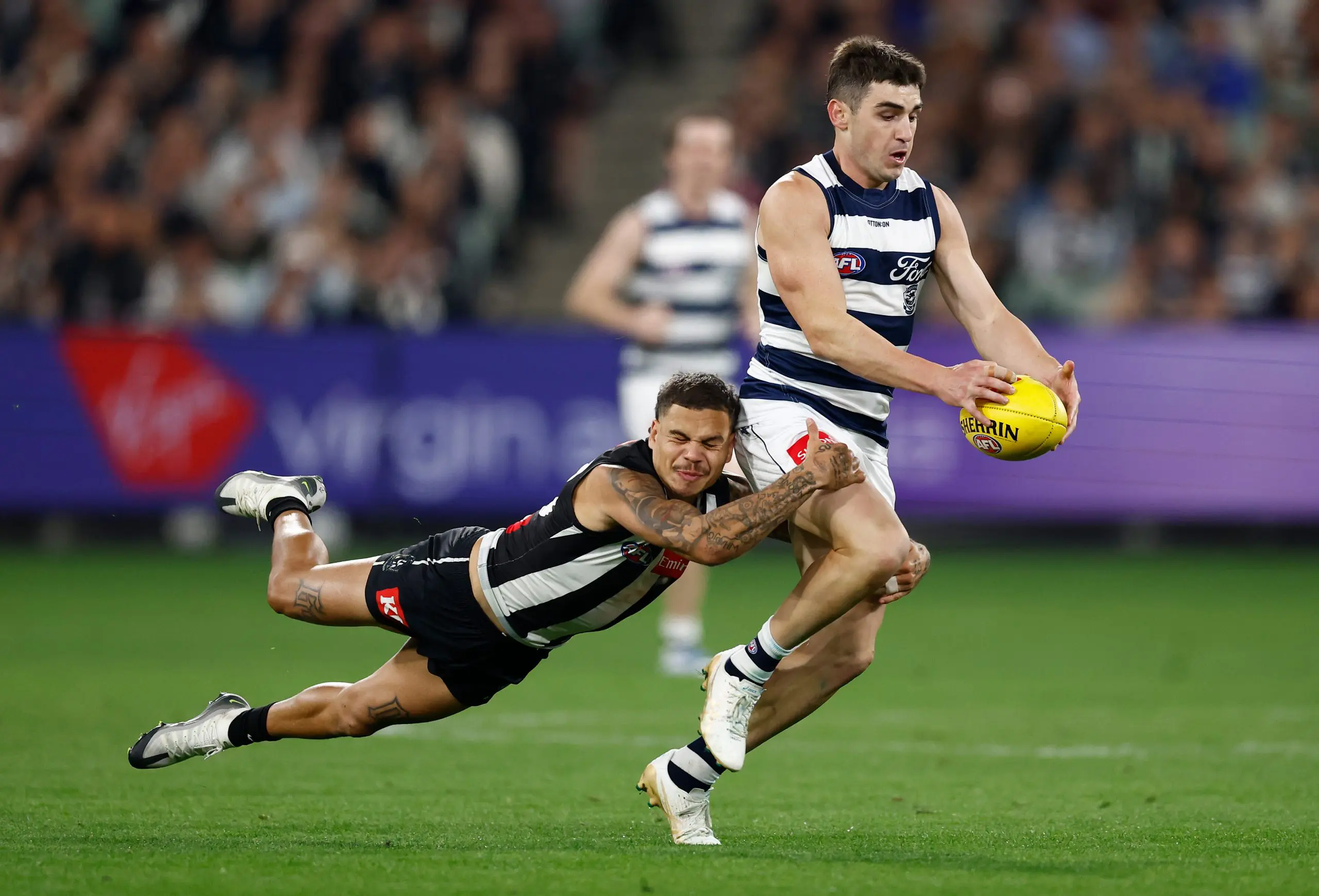 MELBOURNE, AUSTRALIA - MAY 03: Shaun Mannagh of the Cats is tackled by Bobby Hill of the Magpies during the 2025 AFL Round 08 match between the Collingwood Magpies and the Geelong Cats at the Melbourne Cricket Ground on May 3, 2025 in Melbourne, Australia. (Photo by Michael Willson/AFL Photos via Getty Images)