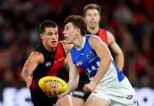 MELBOURNE, AUSTRALIA - MAY 01: Finn O'Sullivan of the Kangaroos handballs whilst being tackled by esapduring the round eight AFL match between Essendon Bombers and North Melbourne Kangaroos at Marvel Stadium, on May 01, 2025, in Melbourne, Australia. (Photo by Josh Chadwick/Getty Images)