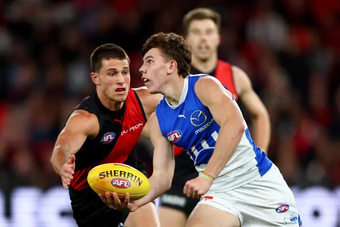 MELBOURNE, AUSTRALIA - MAY 01: Finn O'Sullivan of the Kangaroos handballs whilst being tackled by esapduring the round eight AFL match between Essendon Bombers and North Melbourne Kangaroos at Marvel Stadium, on May 01, 2025, in Melbourne, Australia. (Photo by Josh Chadwick/Getty Images)
