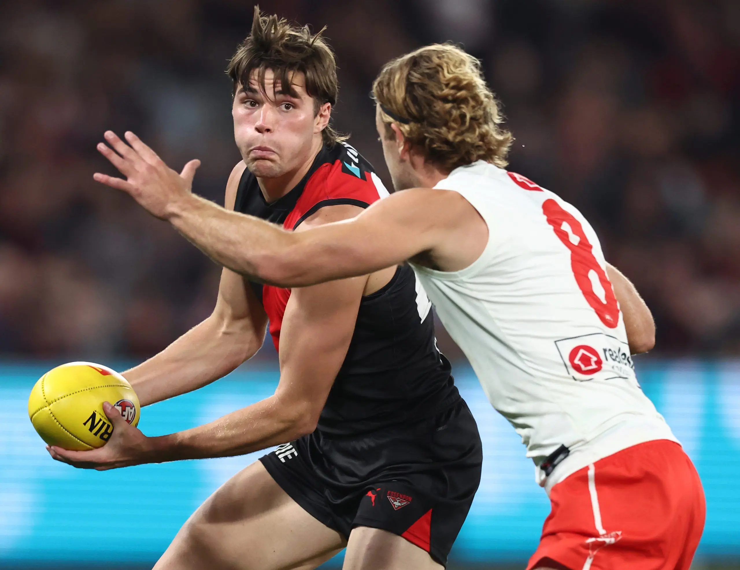 MELBOURNE, AUSTRALIA - MAY 10: Sam Durham of the Bombers handpasses the ball James Rowbottom of the Swans during the 2025 AFL Round 09 match between the Essendon Bombers and the Sydney Swans at Marvel Stadium on May 10, 2025 in Melbourne, Australia. (Photo by James Wiltshire/AFL Photos via Getty Images)