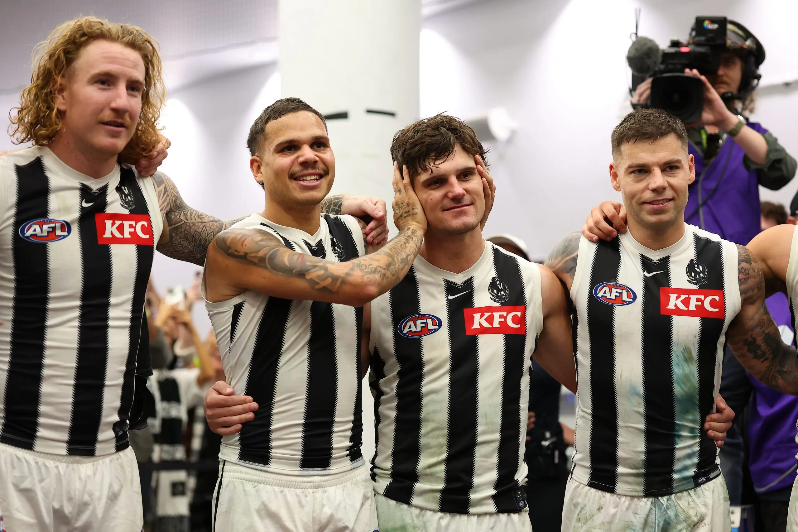 PERTH, AUSTRALIA - MAY 08: Bobby Hill of the Magpies covers the ears of Lachie Schultz as the club song is sung after winning the round nine AFL match between Fremantle Dockers and Collingwood Magpies at Optus Stadium, on May 08, 2025, in Perth, Australia. (Photo by Paul Kane/Getty Images)