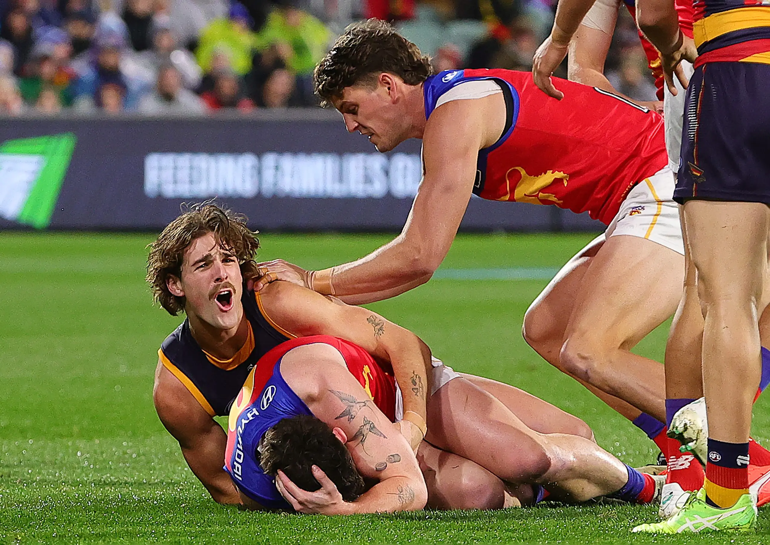 ADELAIDE, AUSTRALIA - JUNE 06: Lachie Neale of the Lions /holds his head after James Peatling of the Crows tackled him to the ground during the 2025 AFL Round 13 match between the Adelaide Crows and the Brisbane Lions at Adelaide Oval on June 6, 2025 in Adelaide, Australia. (Photo by Sarah Reed/AFL Photos via Getty Images)