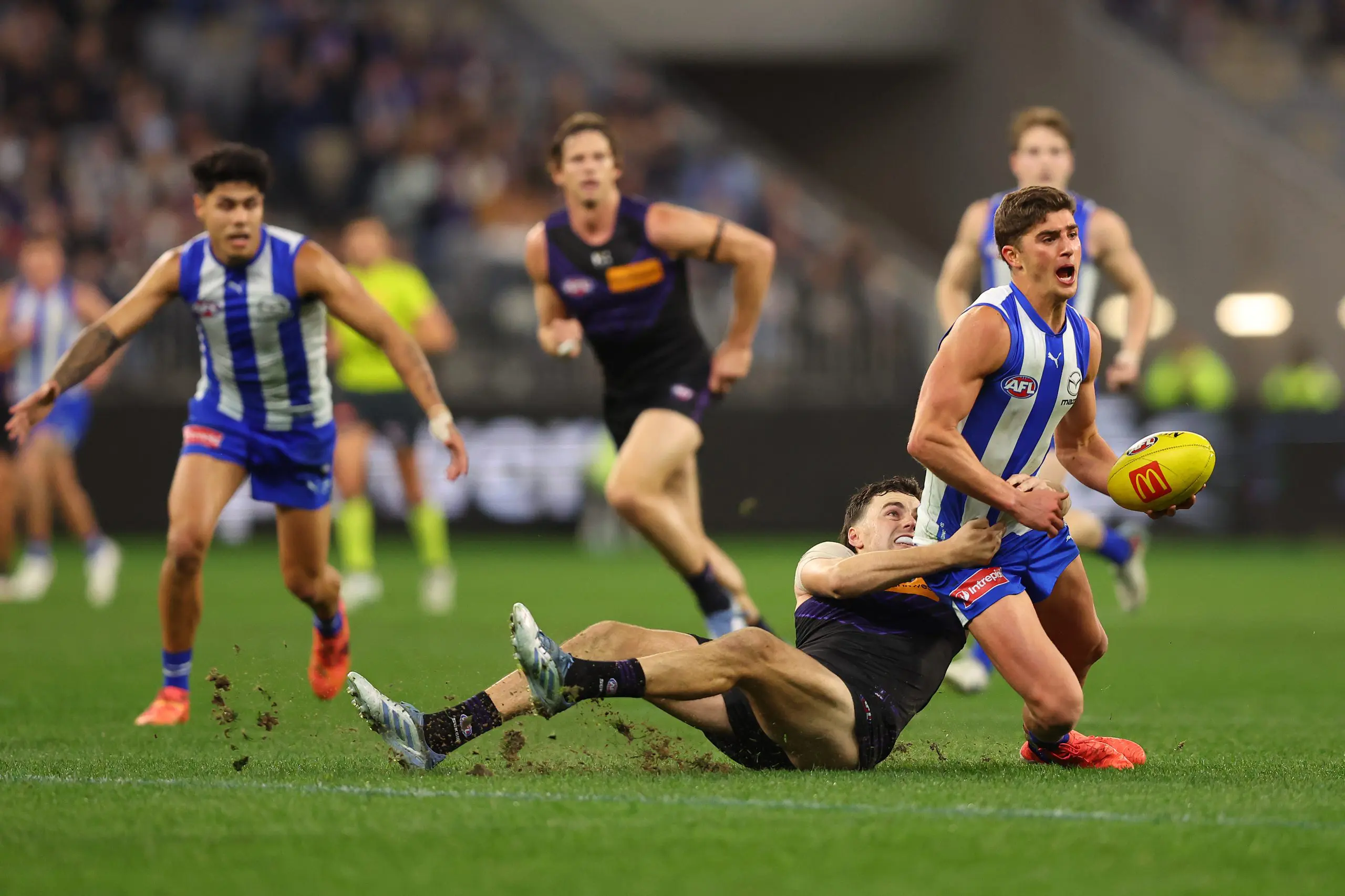 PERTH, AUSTRALIA - JUNE 14: Jordan Clark of the Dockers tackles Harry Sheezel of the Kangaroos during the round 14 AFL match between North Melbourne Kangaroos and Fremantle Dockers at Optus Stadium, on June 14, 2025, in Perth, Australia. (Photo by Paul Kane/Getty Images)