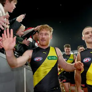 MELBOURNE, AUSTRALIA - JULY 12: Nick Vlastuin of the Tigers and Taj Hotton of the Tigers high fives fans after winning the round 18 AFL match between Richmond Tigers and Essendon Bombers at Melbourne Cricket Ground on July 12, 2025 in Melbourne, Australia. (Photo by Josh Chadwick/AFL Photos/via Getty Images)