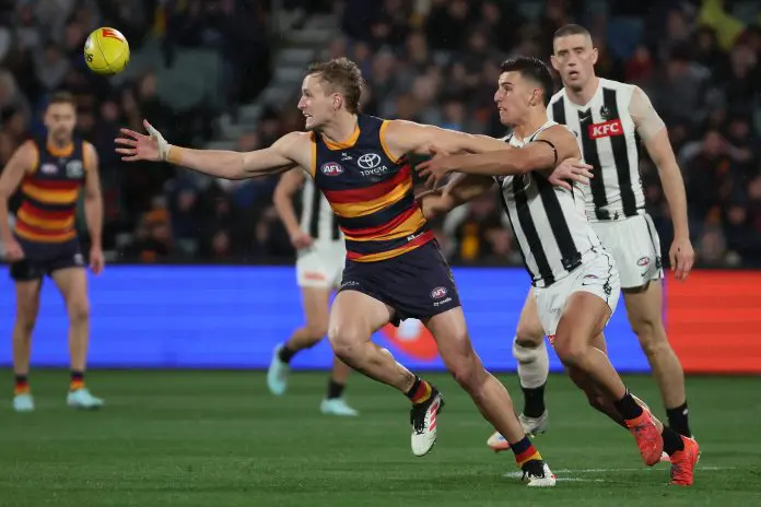 ADELAIDE , AUSTRALIA - AUGUST 16: Jordan Dawson of the Crows is tackled by Nick Daicos of the Magpies during the 2025 AFL Round 23 match between the Adelaide Crows and the Collingwood Magpies at Adelaide Oval on August 16, 2025 in Adelaide, Australia. (Photo by James Elsby/AFL Photos via Getty Images)