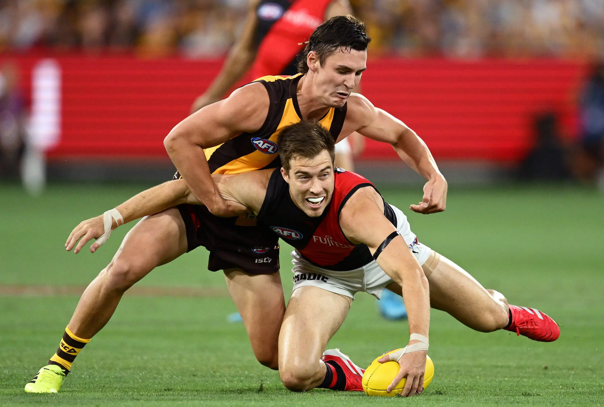 MELBOURNE, AUSTRALIA - MARCH 14: Zach Merrett of the Bombers is tackled by Connor Macdonald of the Hawks during the round one AFL match between Hawthorn Hawks and Essendon Bombers at Melbourne Cricket Ground, on March 14, 2025, in Melbourne, Australia. (Photo by Quinn Rooney/Getty Images)