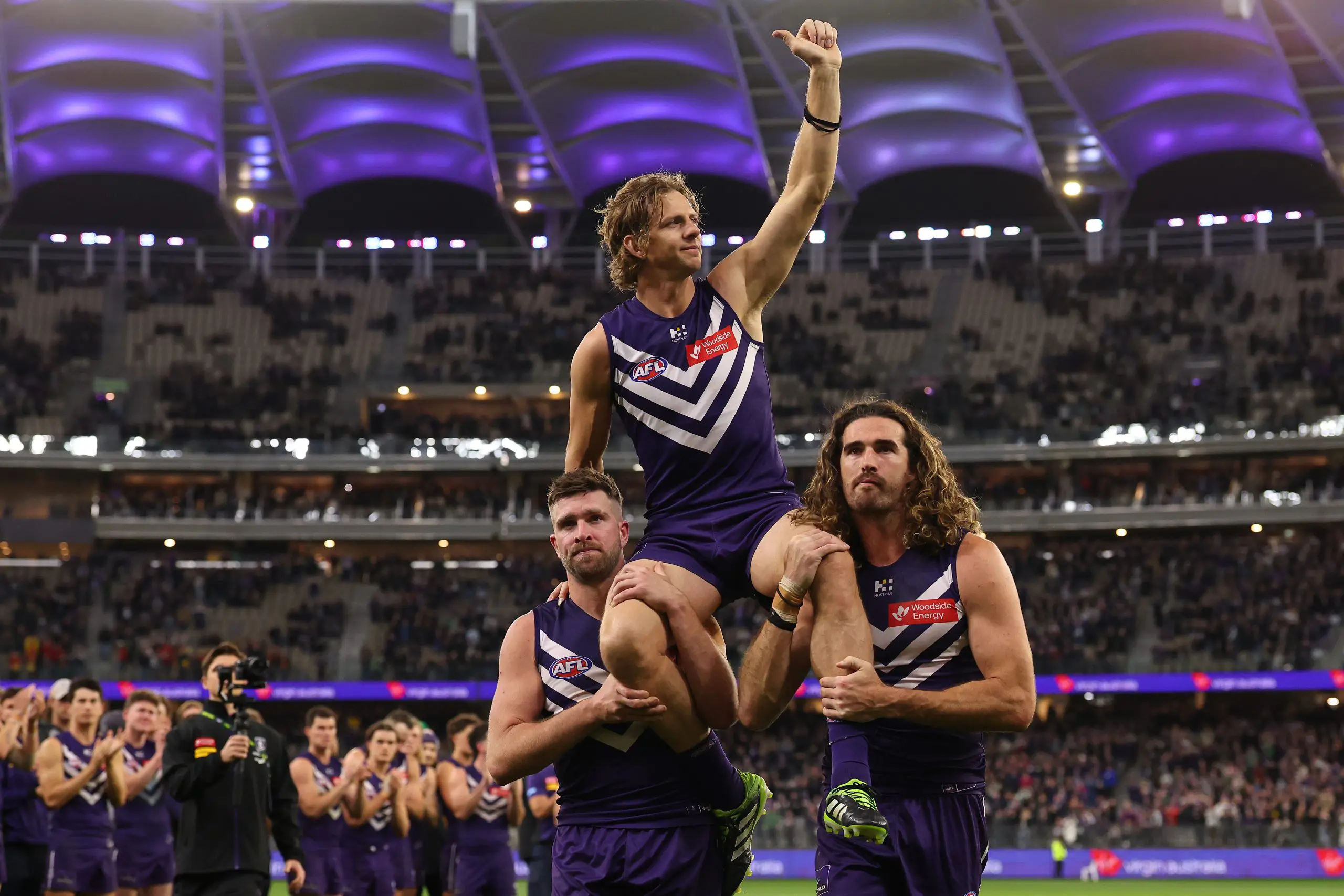 PERTH, AUSTRALIA - SEPTEMBER 06: Nat Fyfe of the Dockers is chaired from the ground by Luke Ryan and Alex Pearce after playing his final game during the AFL Elimination Final match between the Fremantle Dockers and Gold Coast Suns at Optus Stadium on September 06, 2025 in Perth, Australia. (Photo by Paul Kane/Getty Images)