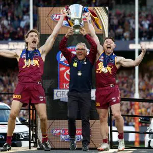 MELBOURNE, AUSTRALIA - SEPTEMBER 27: Harris Andrews of the Lions, Chris Fagan, Senior Coach of the Lions and Lachie Neale of the Lions celebrate with the Premiership Cup on the dais during the AFL Grand Final match between the Geelong Cats and the Brisbane Lions at the Melbourne Cricket Ground on September 27, 2025 in Melbourne, Australia. (Photo by Michael Willson/AFL Photos via Getty Images)