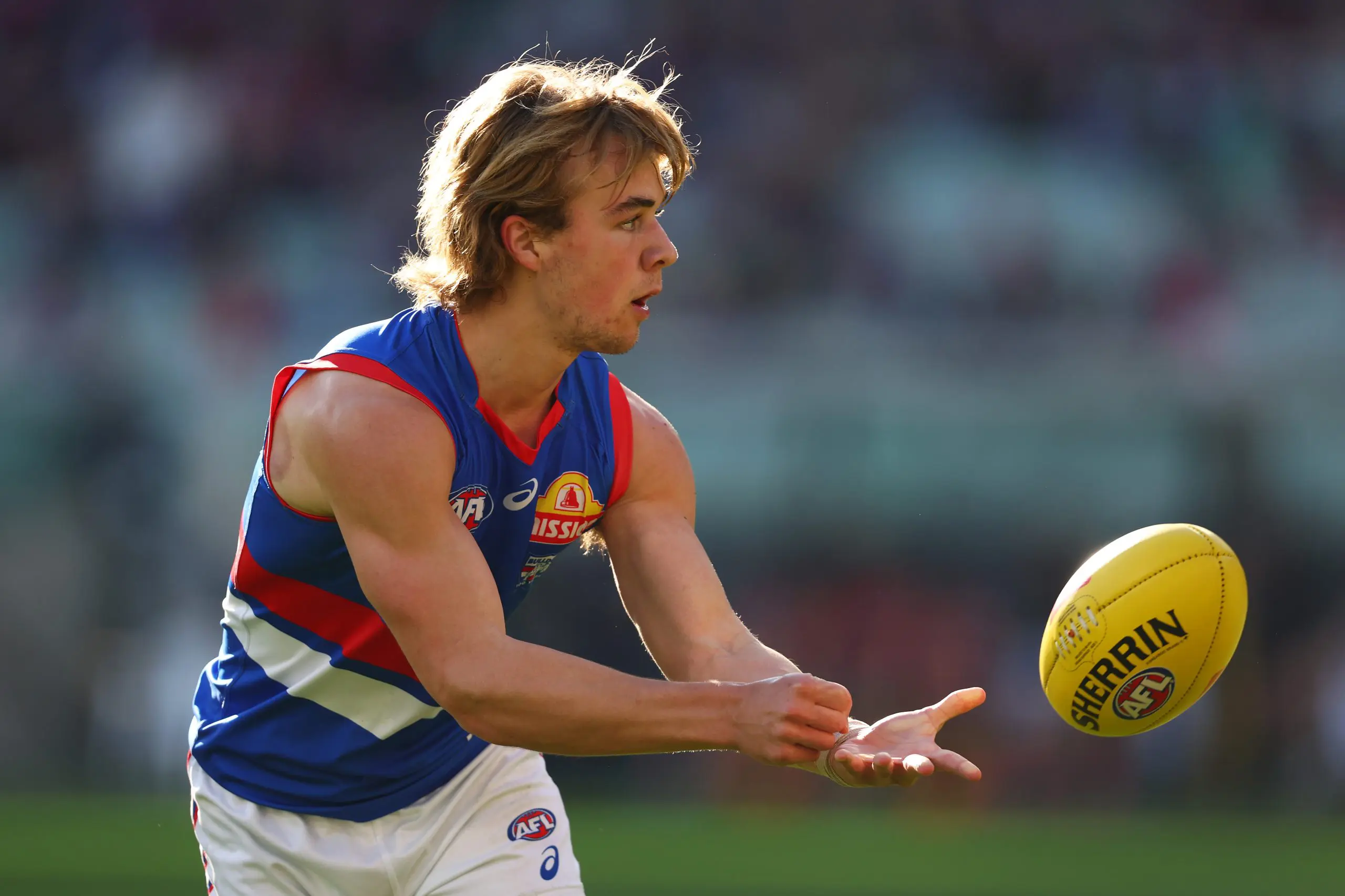 MELBOURNE, AUSTRALIA - AUGUST 10: Ryley Sanders of the Bulldogs handballs during the round 22 AFL match between Melbourne Demons and Western Bulldogs at Melbourne Cricket Ground on August 10, 2025 in Melbourne, Australia. (Photo by Morgan Hancock/Getty Images)