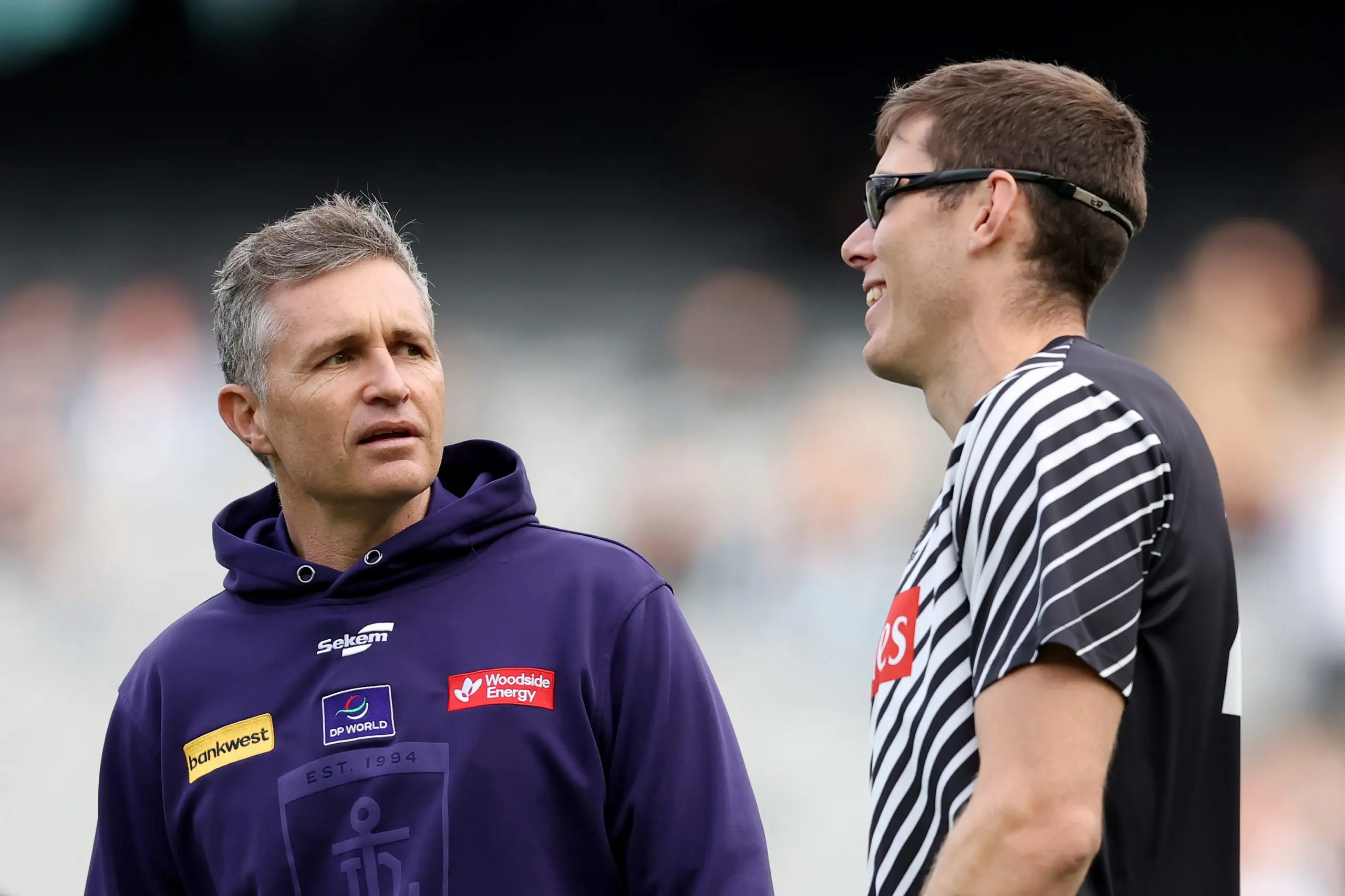MELBOURNE, AUSTRALIA - JULY 20: Justin Longmuir, Senior Coach of the Dockers speaks with Mason Cox of the Magpies ahead of the round 19 AFL match between Collingwood Magpies and Fremantle Dockers at Melbourne Cricket Ground on July 20, 2025 in Melbourne, Australia. (Photo by Robert Cianflone/Getty Images)