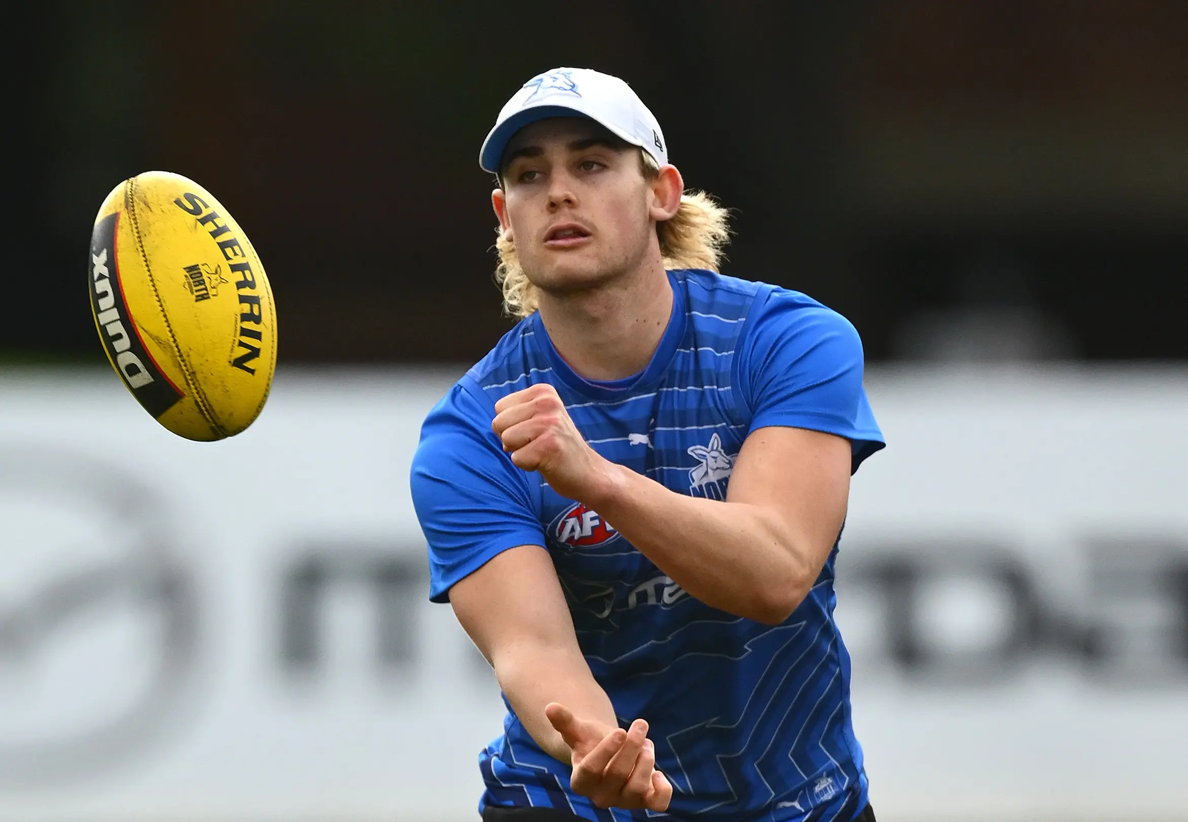 MELBOURNE, AUSTRALIA - JULY 01: Luke Urquhart of the Kangaroos handballs during a North Melbourne Kangaroos AFL training session at Arden Street Ground on July 01, 2025 in Melbourne, Australia. (Photo by Quinn Rooney/Getty Images)