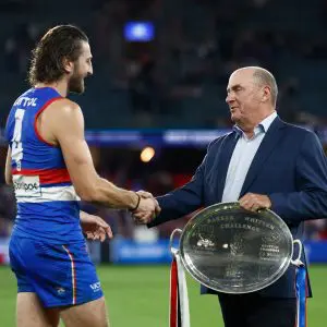 MELBOURNE, AUSTRALIA - APRIL 20: Marcus Bontempelli of the Bulldogs is presented with the Barker-Whitten Challenge plate by Ted Whitten Jnr during the 2025 AFL Round 06 match between the Western Bulldogs and the St Kilda Saints at Marvel Stadium on April 20, 2025 in Melbourne, Australia. (Photo by Michael Willson/AFL Photos via Getty Images)