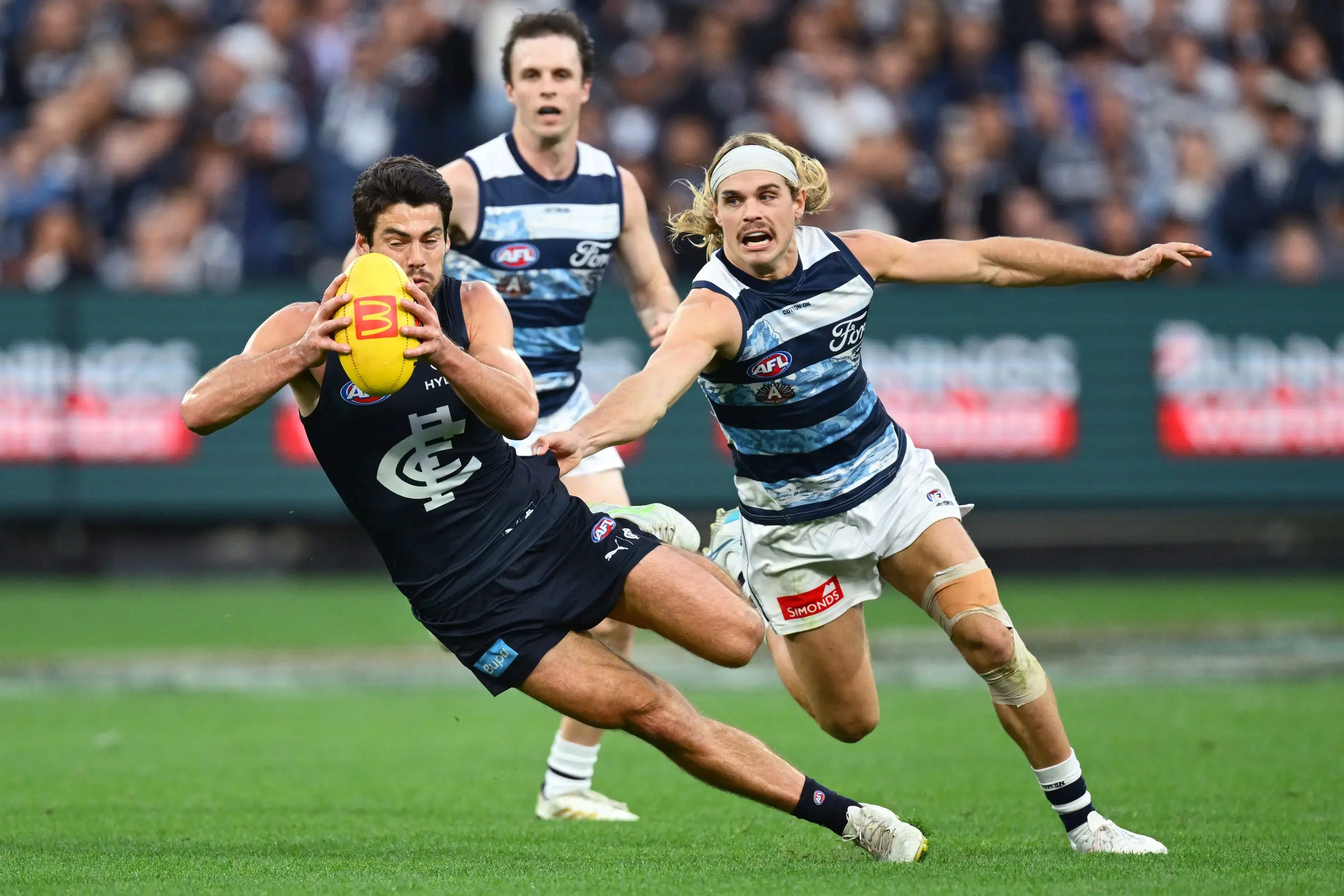 MELBOURNE, AUSTRALIA - APRIL 27: George Hewett of the Blues is tackled by Bailey Smith of the Cats during the round seven AFL match between Carlton Blues and Geelong Cats at Melbourne Cricket Ground, on April 27, 2025, in Melbourne, Australia. (Photo by Quinn Rooney/Getty Images)