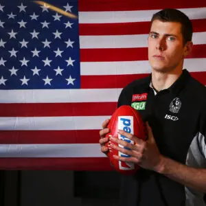 MELBOURNE, AUSTRALIA - SEPTEMBER 24: American Mason Cox of the Magpies poses in front of his national flag during a Collingwood Magpies AFL media opportunity at the Holden Centre on September 24, 2018 in Melbourne, Australia. Cox will be the first American to play in an Australian Football League Grand Final this Saturday. (Photo by Michael Dodge/Getty Images)