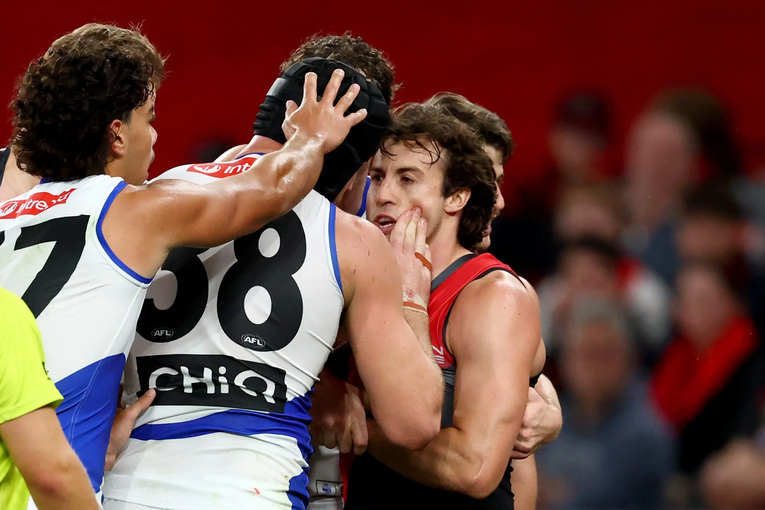 MELBOURNE, AUSTRALIA - MARCH 28: Tristan Xerri of the Kangaroos wipes blood on the face of Andrew McGrath of the Bombers during the round three AFL match between Essendon Bombers and North Melbourne Kangaroos at Marvel Stadium, on March 28, 2026, in Melbourne, Australia. (Photo by Josh Chadwick/Getty Images)