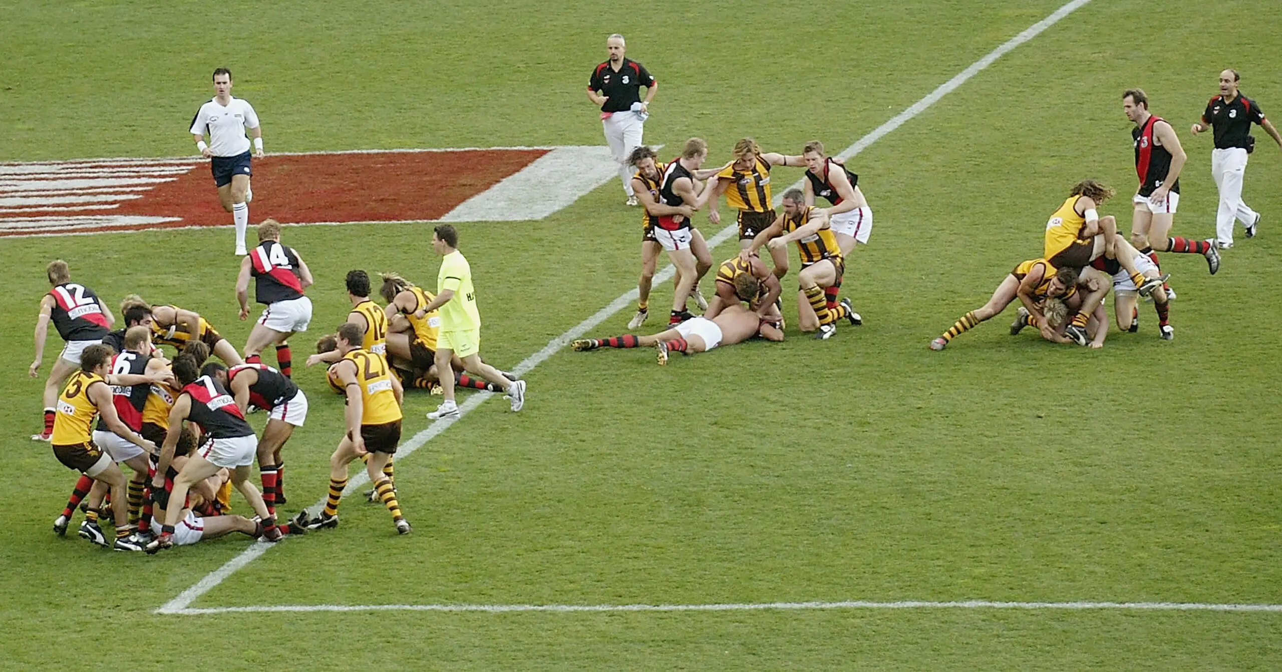 MELBOURNE, AUSTRALIA - JUNE 5: Essendon and Hawthorn players during an all in mellee in the round eleven AFL match between the Hawthorn Hawks and the Essendon Bombers at the Melbourne Cricket Ground June 5 2004 in Melbourne, Australia. (Photo by Stuart Hannagan/Getty Images)