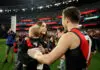MELBOURNE, AUSTRALIA - AUGUST 21: Zach Merrett of the Bombers is congratulated by his wife Alexandra and son Jude during his 250th game the round 24 AFL match between Essendon Bombers and Carlton Blues at Melbourne Cricket Ground on August 21, 2025 in Melbourne, Australia. (Photo by Robert Cianflone/Getty Images)