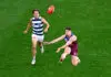 MELBOURNE, AUSTRALIA - SEPTEMBER 27: Lachie Neale of the Lions kicks a goal ahead of Jhye Clark of the Cats during the AFL Grand Final match between the Geelong Cats and the Brisbane Lions at the Melbourne Cricket Ground on September 27, 2025 in Melbourne, Australia. (Photo by Adam Trafford/AFL Photos via Getty Images)