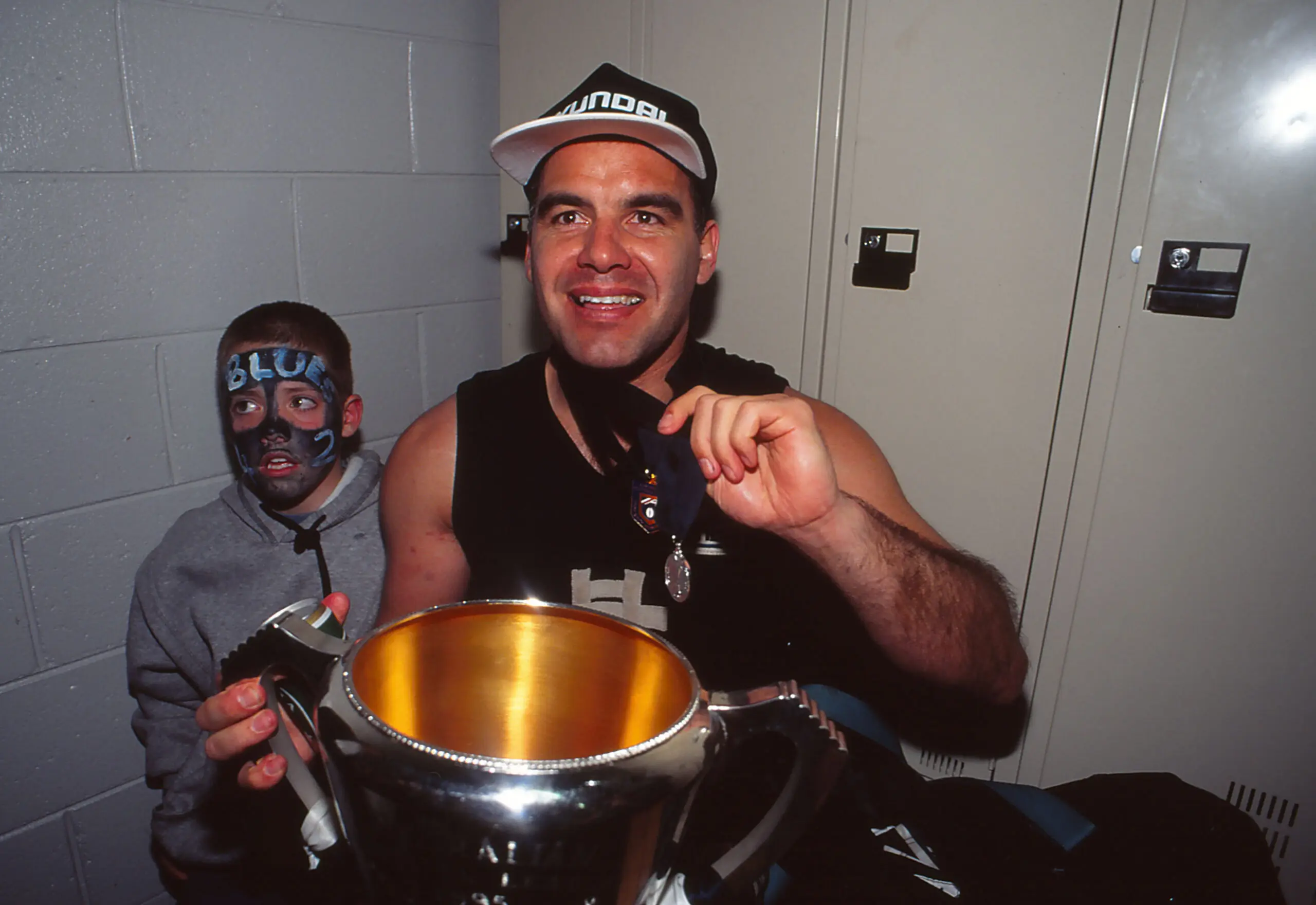 MELBOURNE, AUSTRALIA - 1995: Greg Williams of the Blues celebrates with the premiership trophy and the Coleman medal after the 1995 AFL Grand Final match between Carlton and Geelong in Melbourne, Australia. (Photo by Getty Images)