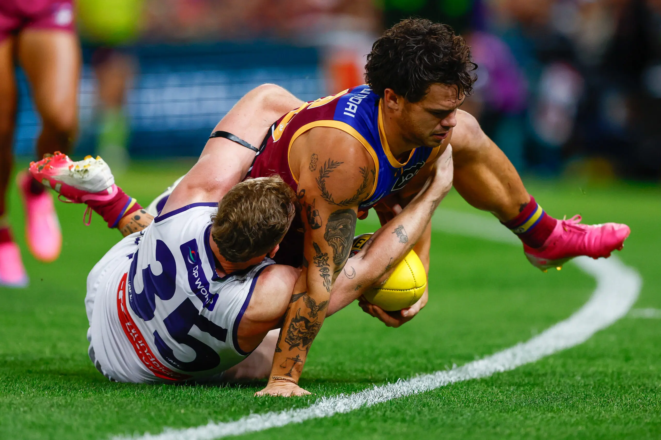 BRISBANE, AUSTRALIA - MAY 30: Cam Rayner of the Lions is tackled by Josh Treacy of the Dockers during the 2026 AFL Round 12 match between the Brisbane Lions and the Fremantle Dockers at the Gabba on May 30, 2026 in Brisbane, Australia. (Photo by Russell Freeman/AFL Photos via Getty Images)