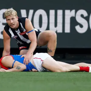 MELBOURNE, AUSTRALIA - JUNE 08: Brody Mihocek of the Demons lays injured as Billy Frampton of the Magpies looks on during the 2026 AFL Round 13 match between the Collingwood Magpies and the Melbourne Demons at the Melbourne Cricket Ground on June 8, 2026 in Melbourne, Australia. (Photo by Michael Willson/AFL Photos via Getty Images)
