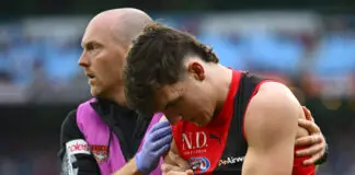 Young pair see their outings cut short as Melbourne pull away from Essendon MELBOURNE, AUSTRALIA - JUNE 13: Archie Roberts of the Bombers is helped from the ground by trainers during the round 14 AFL match between Melbourne Demons and Essendon Bombers at Melbourne Cricket Ground, on June 13, 2026, in Melbourne, Australia. (Photo by Quinn Rooney/Getty Images)