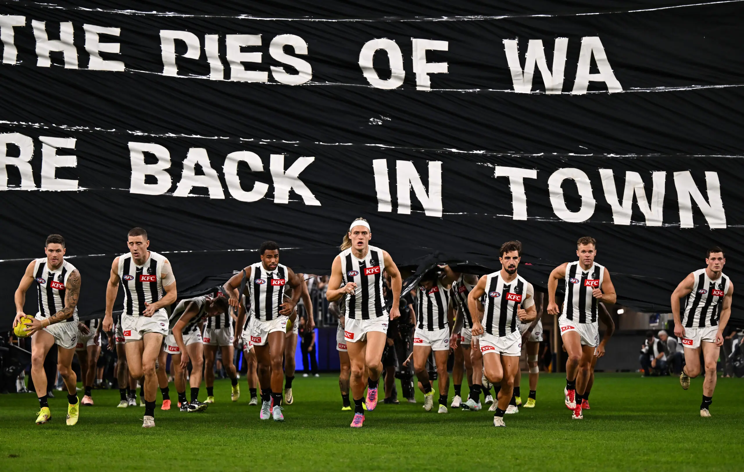 PERTH, AUSTRALIA - MAY 08: The Magpies break the banner during the 2025 AFL Round 09 match between the Fremantle Dockers and the Collingwood Magpies at Optus Stadium on May 8, 2025 in Perth, Australia. (Photo by Daniel Carson/AFL Photos via Getty Images)