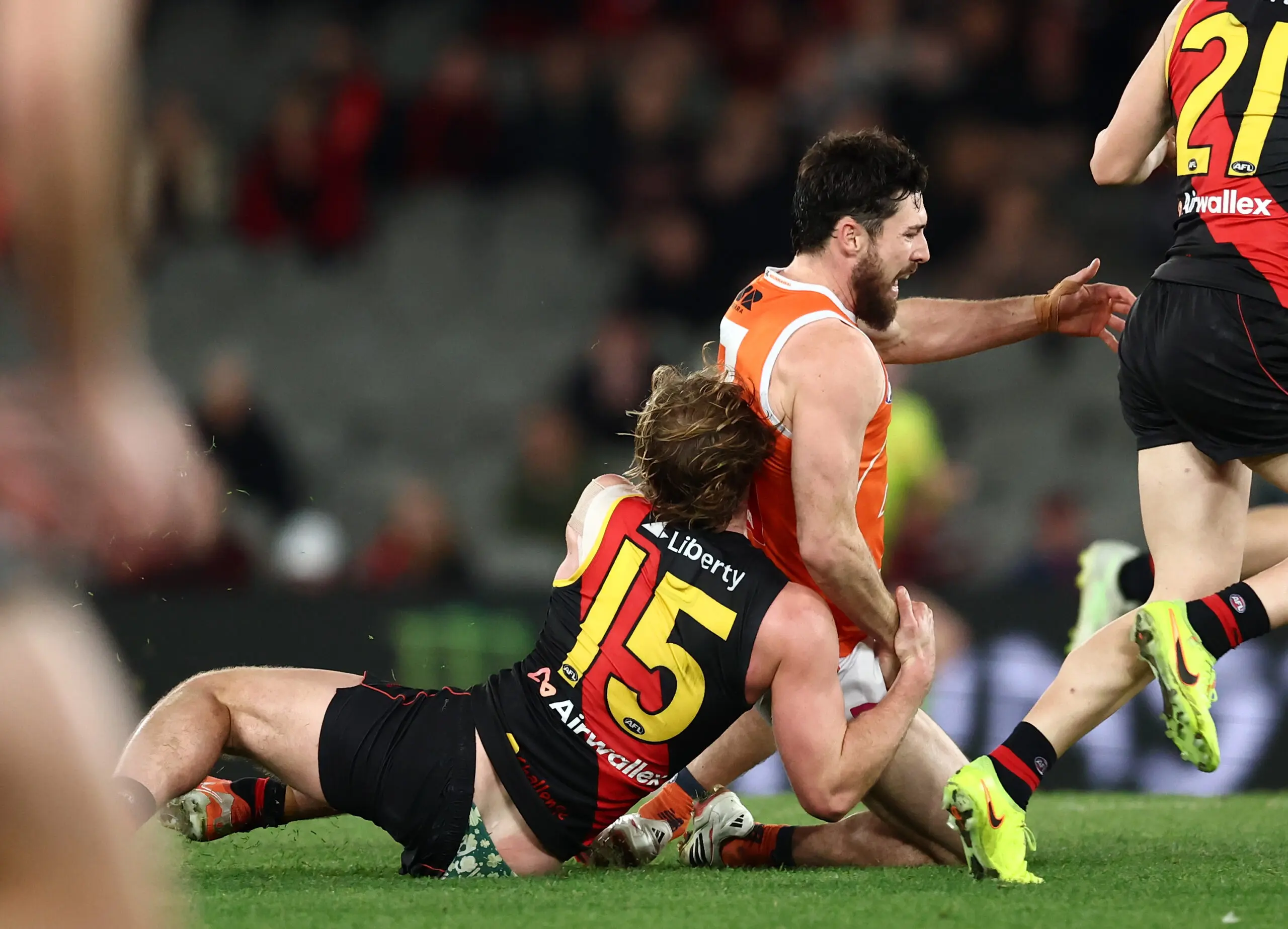MELBOURNE, AUSTRALIA - JULY 19: Lachie Ash of the Giants is tackled by Dyson Sharp of the Bombers during the 2026 AFL Round 19 match between the Essendon Bombers and the GWS Giants at Marvel Stadium on July 19, 2026 in Melbourne, Australia. (Photo by James Wiltshire/AFL Photos via Getty Images)