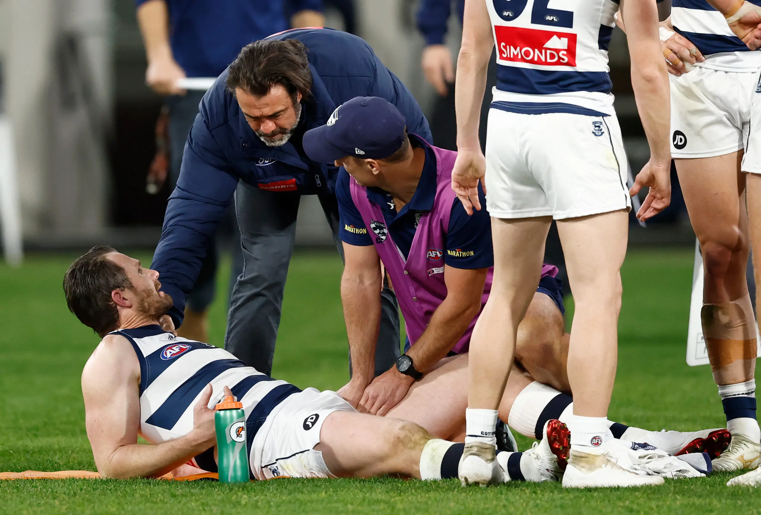 MELBOURNE, AUSTRALIA - JULY 24: Patrick Dangerfield of the Cats receives treatment on his groin as Chris Scott, Senior Coach of the Cats looks on during the 2026 AFL Round 20 match between the Melbourne Demons and the Geelong Cats at the Melbourne Cricket Ground on July 24, 2026 in Melbourne, Australia. (Photo by Michael Willson/AFL Photos via Getty Images)