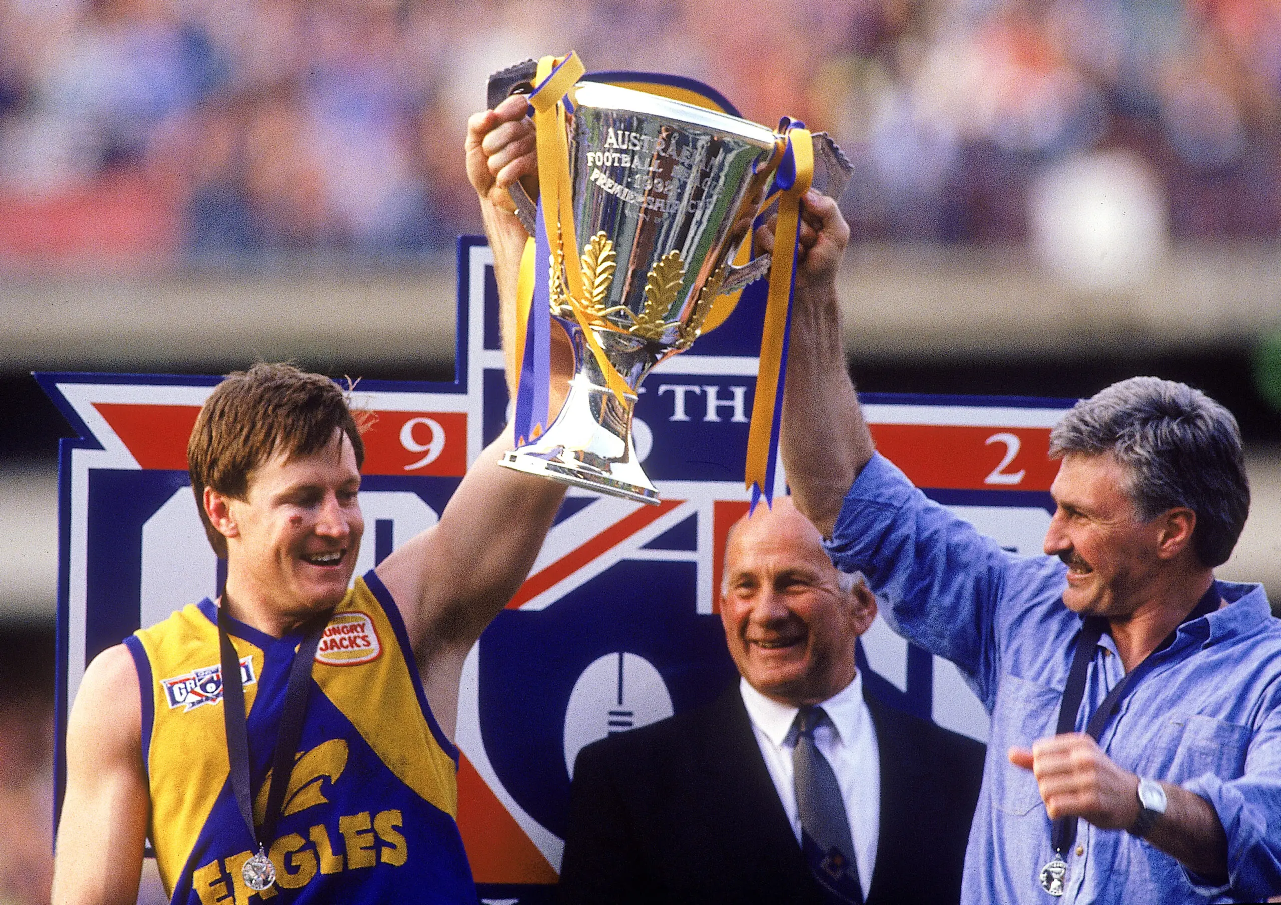 MELBOURNE, AUSTRALIA - SEPTEMBER 26: John Worsfold and Mick Malthouse of the Eagles holds aloft the premiership trophy after winning the AFL Grand Final match between the Geelong Cats and the West Coast Eagles at the Melbourne Cricket Ground on September 26, 1992 in Melbourne, Australia. (Photo by Tony Feder/Getty Images)