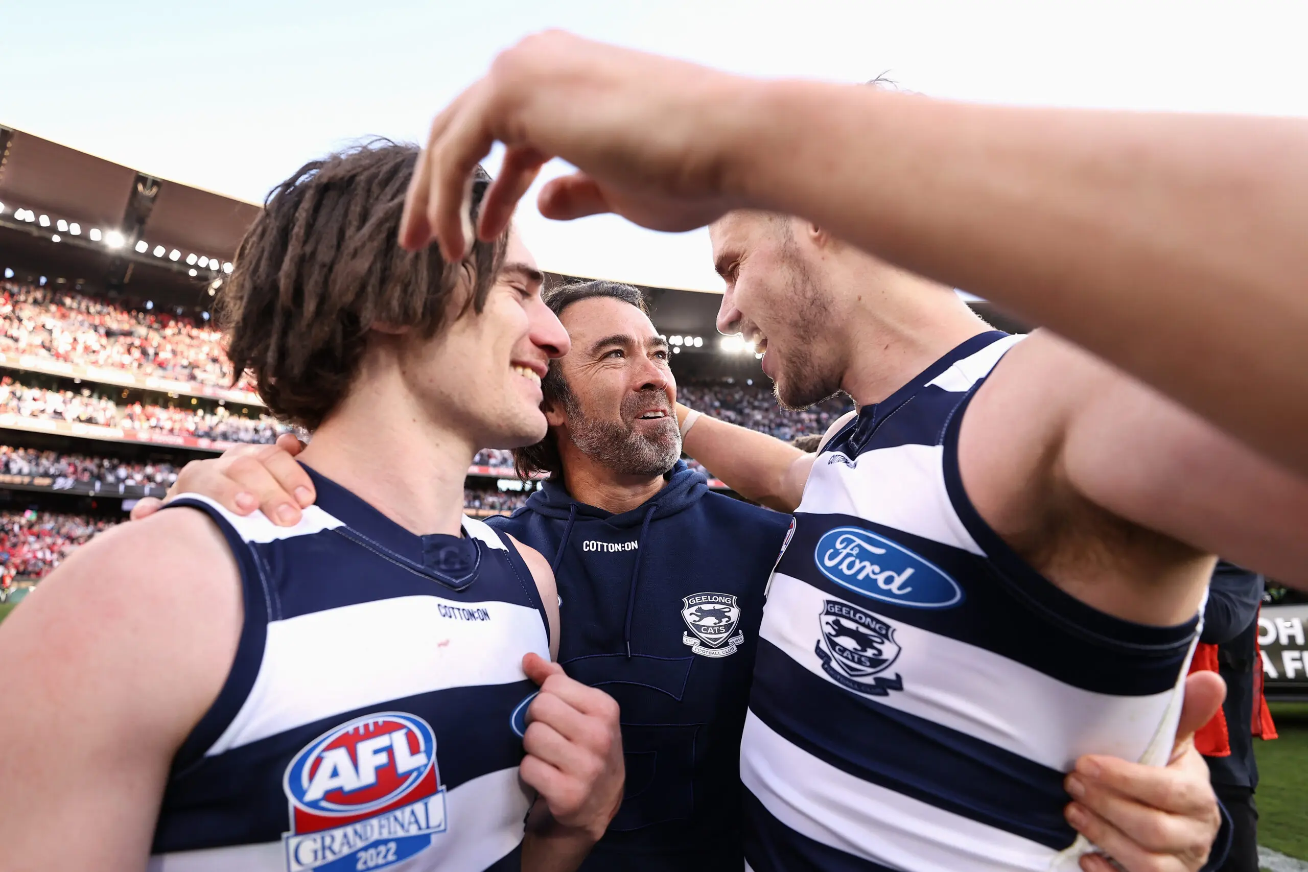MELBOURNE, AUSTRALIA - SEPTEMBER 24: Cats head coach Chris Scott celebrates with Gryan Miers of the Cats and Jake Kolodjashnij of the Cats after winning the 2022 AFL Grand Final match between the Geelong Cats and the Sydney Swans at the Melbourne Cricket Ground on September 24, 2022 in Melbourne, Australia. (Photo by Cameron Spencer/AFL Photos/via Getty Images)