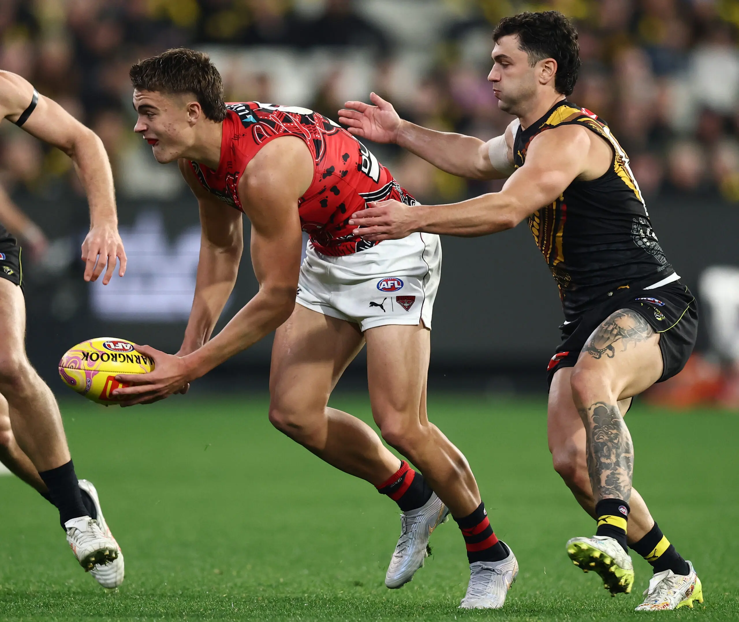 MELBOURNE, AUSTRALIA - MAY 22: Sullivan Robey of the Bombers handpasses the ball with Tim Taranto of the Tigers during the 2026 AFL Round 11 match between the Richmond Tigers and the Essendon Bombers at the Melbourne Cricket Ground on May 22, 2026 in Melbourne, Australia. (Photo by James Wiltshire/AFL Photos via Getty Images)