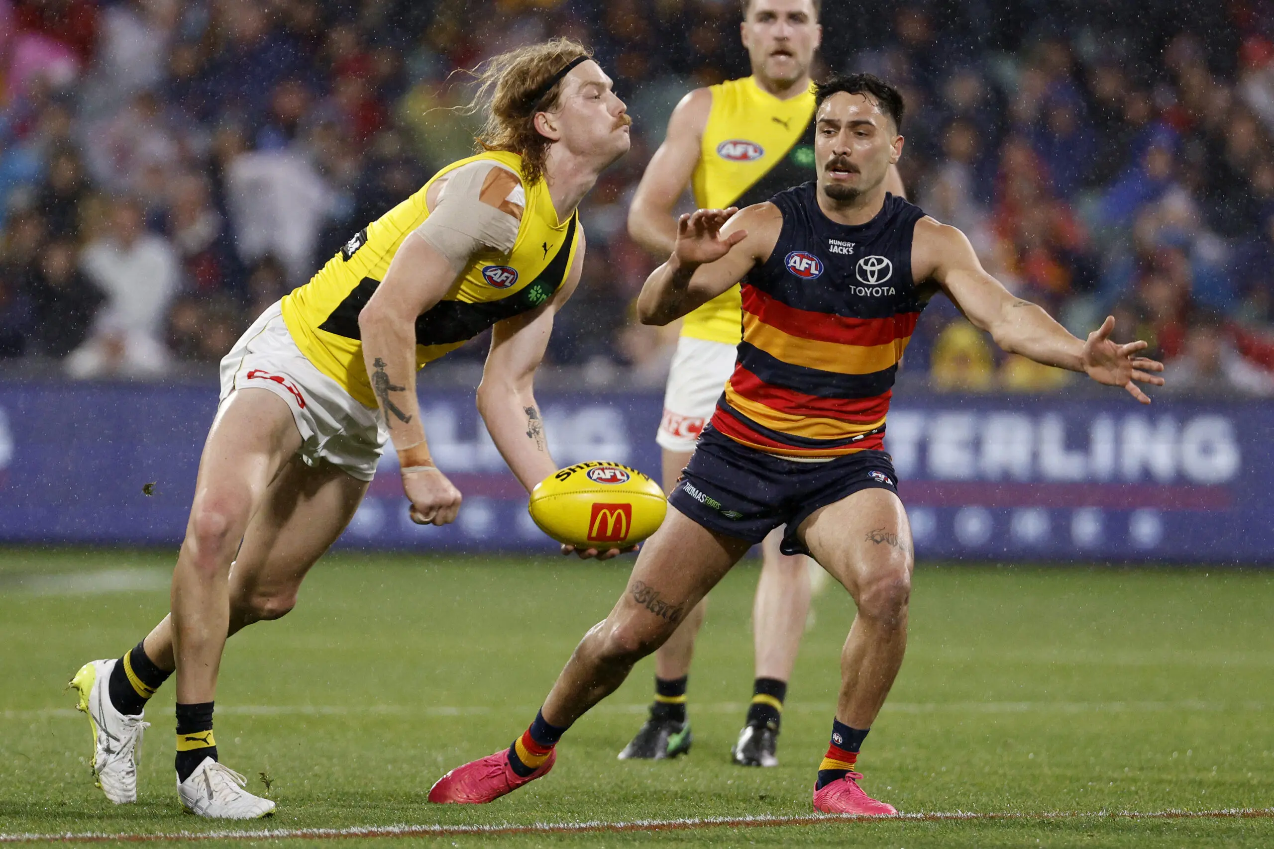 ADELAIDE, AUSTRALIA - AUGUST 08: Kye Annand of the Tigers is tackled by Izak Rankine of the Crows during the 2026 AFL Round 22 match between the Adelaide Crows and the Richmond Tigers at Adelaide Oval on August 8, 2026 in Adelaide, Australia. (Photo by James Elsby/AFL Photos via Getty Images)