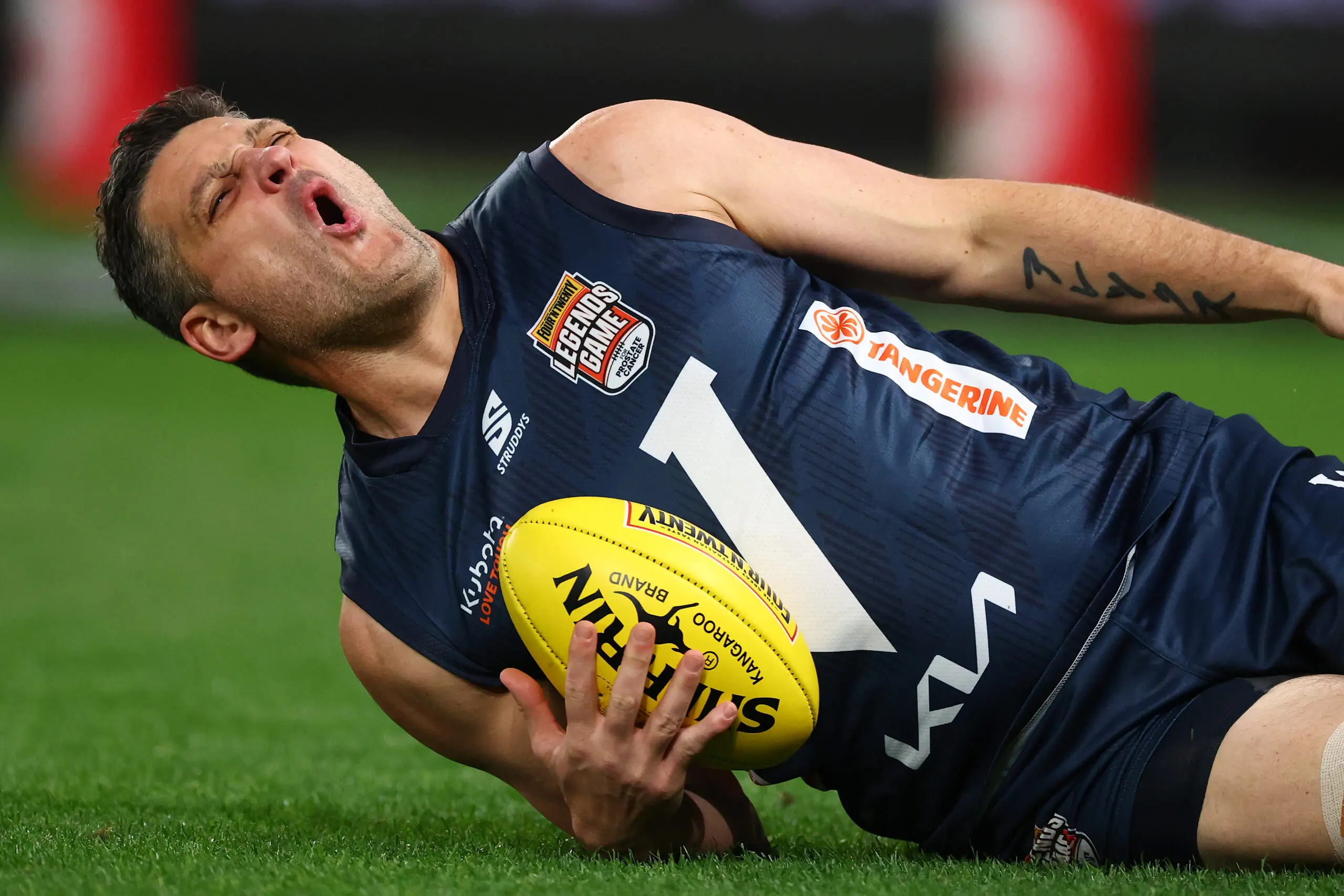 MELBOURNE, AUSTRALIA - AUGUST 27: Brendan Fevola of Victoria reacts after injuring his knee during the Four'N Twenty Legends Game at Marvel Stadium on August 27, 2026 in Melbourne, Australia. (Photo by Daniel Pockett/Getty Images)