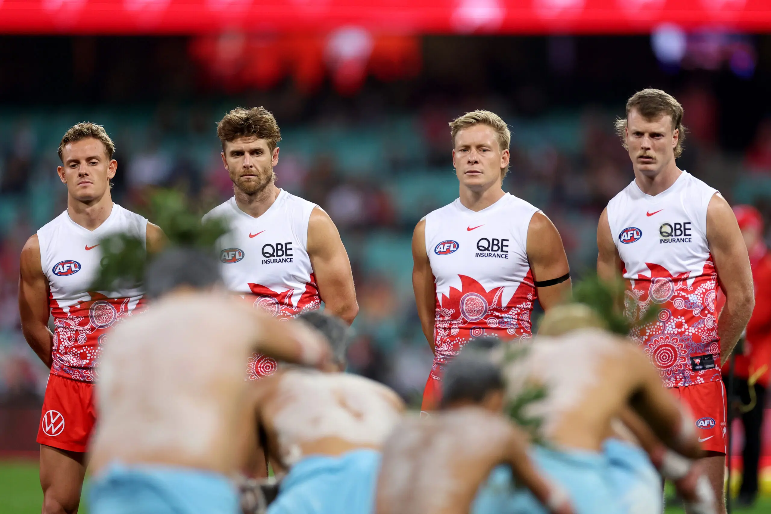 SYDNEY, AUSTRALIA - MAY 16: Corey Warner, Dane Rampe, Isaac Heeney and Nick Blakey of the Swans watch on as indigenous dancers perform ahead of the round ten AFL match between Sydney Swans and Carlton Blues at Sydney Cricket Ground, on May 16, 2025, in Sydney, Australia. (Photo by Cameron Spencer/Getty Images)